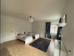 sala de estar con 2 camas y lámpara en Spacious room in shared accommodation, en Gentofte