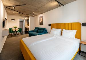 a bedroom with a large bed and a blue chair at Noir Hotel in Szeged