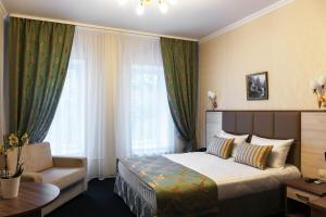 モスクワにあるセブン ヒルズ Brestskaya ホテルのベッドとソファ付きのホテルルーム