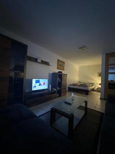 un soggiorno con un divano, un tavolo e una TV di Studio Noyer C a Leukerbad