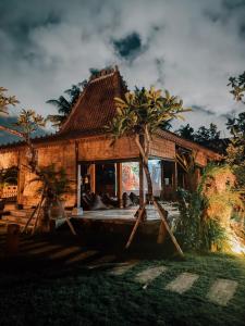 dom z łodzią przed nim w obiekcie Nunu Bali Eco Friendly Retreat w mieście Canggu