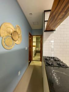 a kitchen with a stove and some straw hats on the wall at Villa Palmeira Flecheiras 101 in Flecheiras +7 photos
