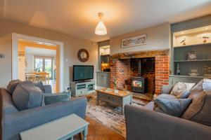 a living room with two couches and a fireplace at Dibley Cottage Mundesley in Mundesley
