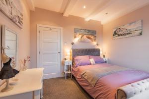 a bedroom with a bed and a desk and a bed sidx sidx sidx at Dibley Cottage Mundesley in Mundesley
