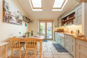 a kitchen with a table and chairs and a window at Dibley Cottage Mundesley in Mundesley