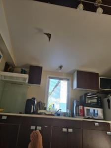 a kitchen with a persons feet on a kitchen counter at Mobile home O'Hara Chez Mica in Sigean