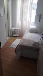 um quarto com 2 camas, uma mesa e uma janela em Hospedaria Pôr do Sol em Funchal