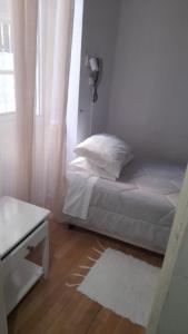 フンシャルにあるHospedaria Pôr do Solの小さなベッドルーム(ベッド1台、窓付)