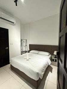 a bedroom with a large bed with white sheets at Lodge 43 House in George Town