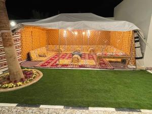 a tent with mats and rugs on the ground at Chalet Gheed Luxury in Buraydah