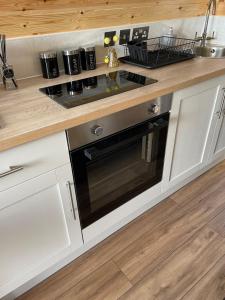 a kitchen with a stove and a counter top at The Sandy Pod in Stornoway
