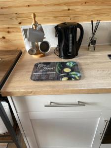 a wooden counter top with a coffee pot on it at The Sandy Pod in Stornoway