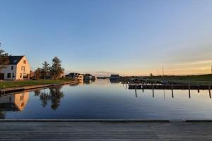 una masa de agua con una casa y un muelle en Long-stay family house Meerstad en Groninga