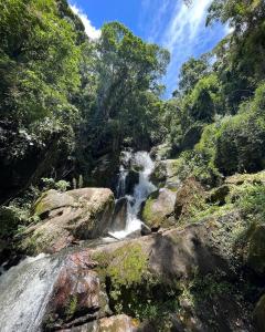 uma cascata no meio de uma floresta em chalé completo na fazenda em Bocaina de Minas