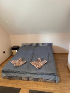 ein Bett mit zwei Paar Schuhen drauf in der Unterkunft Ponty Apartman in Kunfehértó