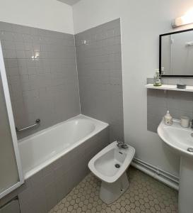 y baño con bañera, aseo y lavamanos. en Bel appartement à 9 minutes de Paris, en Bois-Colombes