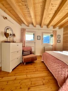 a bedroom with a bed and a dresser and two windows at CIELO E TERRA Chalet a Zencheri in Piazza