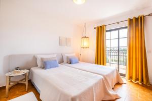 a bedroom with two beds and a large window at Apartamentos Turisticos Novochoro in Albufeira