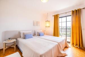 1 Schlafzimmer mit 2 Betten und einem großen Fenster in der Unterkunft Apartamentos Turisticos Novochoro in Albufeira