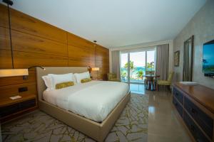 a bedroom with a large bed and a large window at Royal Blues Hotel in Deerfield Beach