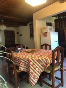 cocina con mesa, 2 sillas y nevera en Bello Coihue en Trevelín