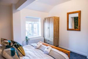 1 dormitorio con cama, espejo y ventana en Balmoral House en Timperley