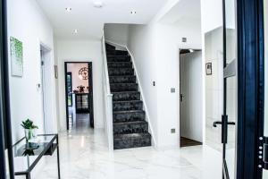 a hallway with a staircase in a house at Balmoral House in Timperley