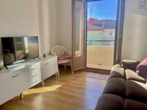 een woonkamer met een bank en een flatscreen-tv bij Ostadar etxea Centrico apartamento reformado in Bermeo