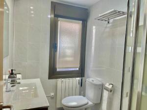 een badkamer met een toilet, een wastafel en een raam bij Ostadar etxea Centrico apartamento reformado in Bermeo