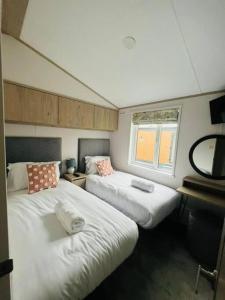 a room with two beds and a window at Wag Tail Lodge with Hot Tub in Barmby on the Moor