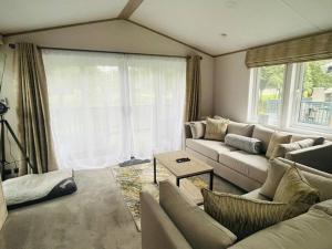 a living room with a couch and a table at Wag Tail Lodge with Hot Tub in Barmby on the Moor