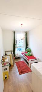 a living room with a bed and a red rug at Long-stay family house Meerstad in Groningen