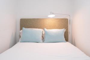 łóżko z białą pościelą i niebieskimi poduszkami w obiekcie TravelingToLisbon 98 - Alfama w Lizbonie