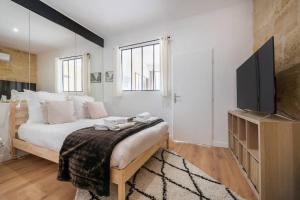 - une chambre avec un grand lit et une télévision dans l'établissement Le Bordeaux: Joli appartement climatisé proche gare, à Bordeaux