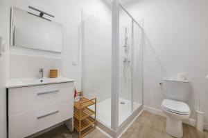 une salle de bain blanche avec toilettes et douche dans l'établissement Le Bordeaux: Joli appartement climatisé proche gare, à Bordeaux