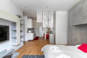 1 Schlafzimmer mit einem weißen Bett und einer Küche in der Unterkunft LA MAR Apartment Chirignago in Marghera