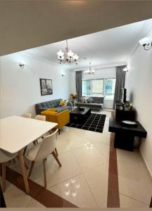een woonkamer met een bank en een tafel bij Smart Home Vacation Home- AYLA in Sharjah