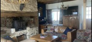 ein Wohnzimmer mit einem Sofa und einem Steinkamin in der Unterkunft The Chamberet Grand Coeur in Chamberet