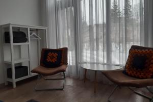 sala de estar con 2 sillas, mesa y ventana en Lazdas en Saulkrasti