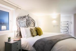 een slaapkamer met een groot wit bed met gele kussens bij Gorgeous Boutique Flat Sleeps 2 in Lyme Regis in Lyme Regis