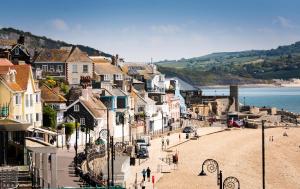 Blick auf eine Stadt mit Menschen, die am Strand spazieren in der Unterkunft Gorgeous Boutique Flat Sleeps 2 in Lyme Regis in Lyme Regis