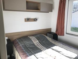 een slaapkamer met een bed en een raam bij KERLANN 4 ETOILES MOBIL HOME 2CHS 1SDB Pont Aven Finistère in Pont-Aven