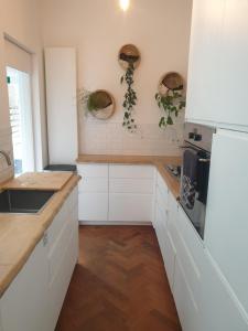 a kitchen with white cabinets and a wooden floor at @Salland in Zwolle