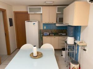 a kitchen with a table and chairs and a refrigerator at Flat Marulhos Resort in Porto De Galinhas
