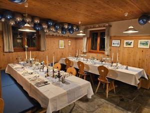 马洛亚Hotel Ristorante Lagrev的一间有长桌长椅的大房间