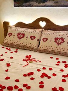 a bed with red roses on it with hearts on it at Il Borgo in Subiaco