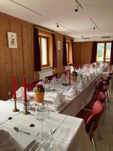 um quarto com uma longa mesa com mesas e cadeiras brancas em Hotel Ristorante Lagrev em Maloja