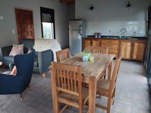 a kitchen with a wooden table and chairs in a room at LA CASITA in Sierra de la Ventana