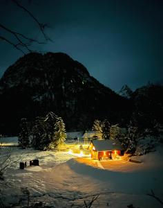 a cabin in the snow at night with a mountain at Radovna Chalet with Panoramic View in Mojstrana