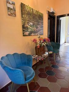 salon z niebieskimi krzesłami i stołem w obiekcie Guest House Subiaco LA DOMUS w mieście Subiaco